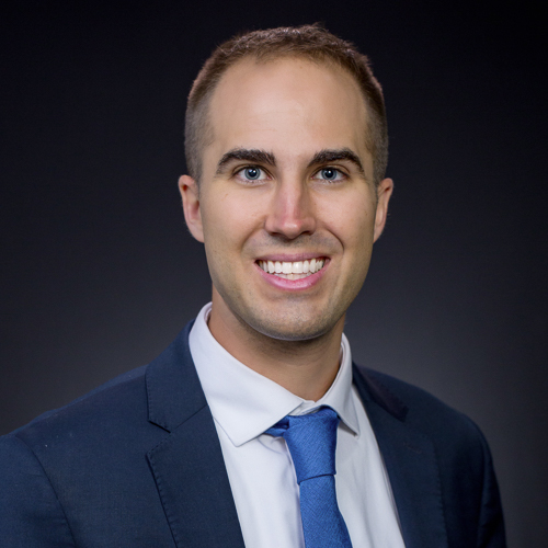 Professional headshot of ophthalmologist Dr. David J. Felsted, wearing a navy suit and tie, smiling in front of a neutral background.