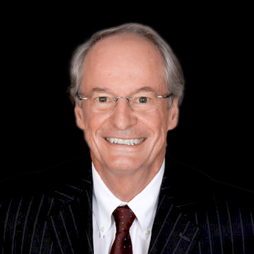 Professional headshot of ophthalmologist Dr. Michael Stagner, smiling in a black suit and red tie, posed against a studio background.