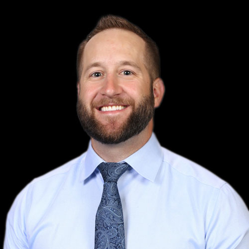 Professional headshot of optometrist Dr. Matthew Hepworth, in a light blue shirt and tie, smiling in front of a black backdrop.