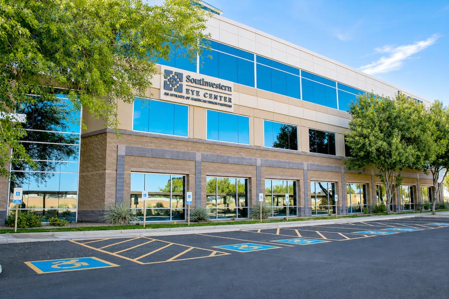 Exterior view of the Southwestern Eye Center Glendale 99th Ave location with building signage, accessible parking, reflective windows, and desert landscaping.