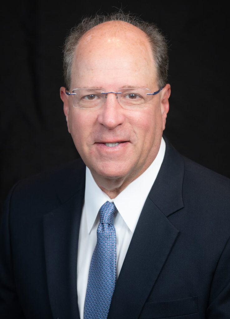 Professional headshot of Dr. Daniel Adelberg against a black backdrop.