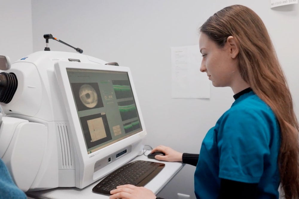 Technician reviewing eye imaging during a routine vs comprehensive eye exam.