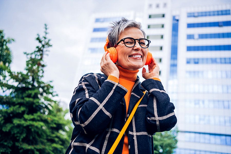 Cataract progression rate: smiling mature woman wearing headphones outdoors, illustrating an active lifestyle with monitored vision changes with Southwestern Eye Center.