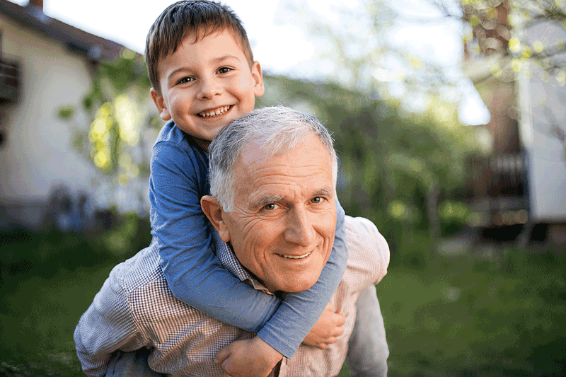 Senior man giving grandson a ride on his back after learning the signs of optic nerve damage from Southwestern Eye Center.