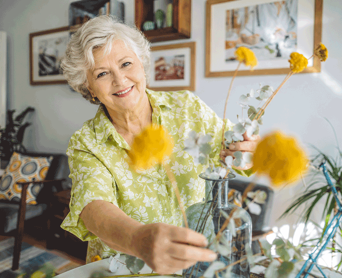 Warm grandmother arranging flowers at home, representing how flashes and floaters can appear during everyday activities and should be evaluated if symptoms are new or sudden.