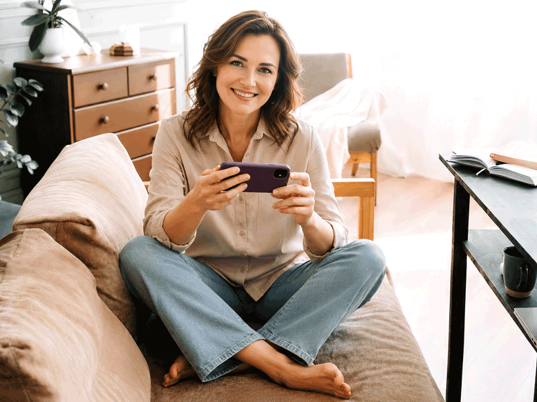 Millennial at home having trouble scrolling her phone because of her presbyopia. Southwestern Eye Center.