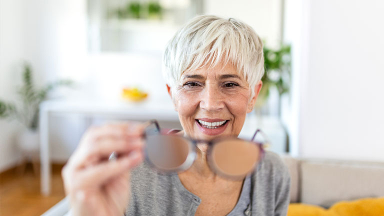 Imagery of a senior woman realizing her vision is recovering from cataract surgery.